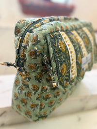 Close-up of hand block printed cotton cosmetic bag showing carved woodblock pattern detail and zippers