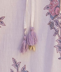 detail of skirt drawstring with tassels and cowrie shells