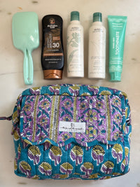 blue and lavender block print cosmetic bag set shown with full-size shampoo and toiletries for scale